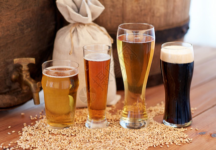 啤酒厂,饮料酒精旧啤酒桶,眼镜袋子与麦芽木制桌子上背景图片