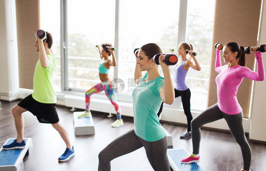 健身,运动,健美操人的群微笑的人健身房的台阶平台上用哑铃弯曲肌肉锻炼图片