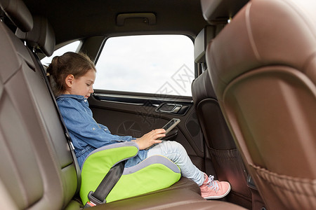 交通,公路旅行,旅游,技术人的快乐的小女孩与平板电脑驾驶汽车安全座椅图片
