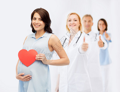 怀孕,医疗,医学,人期望快乐的孕妇,红色的心形触摸她的腹部超过医生产科医生大拇指背景背景图片