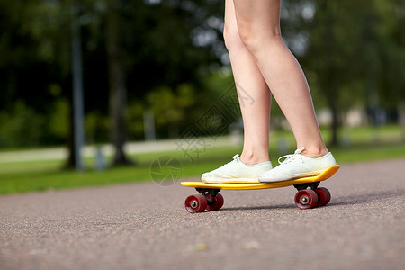 滑板,休闲,极限运动人的近十几岁的女孩腿骑短现代巡洋舰滑板道路上公园图片