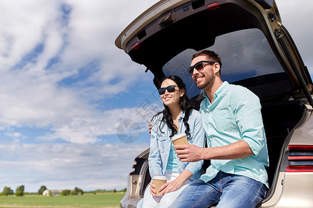 旅行,暑假,公路旅行,休闲人们的快乐的夫妇喝咖啡次杯子坐后备箱的掀背车户外图片