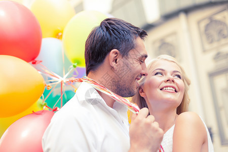暑假,庆祝约会的幸福的夫妇与彩色气球城市图片