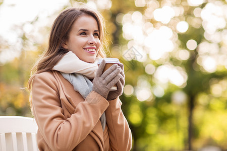 季节,热饮人们的美丽的快乐轻女人喝咖啡茶次纸杯坐长凳上的秋天公园图片