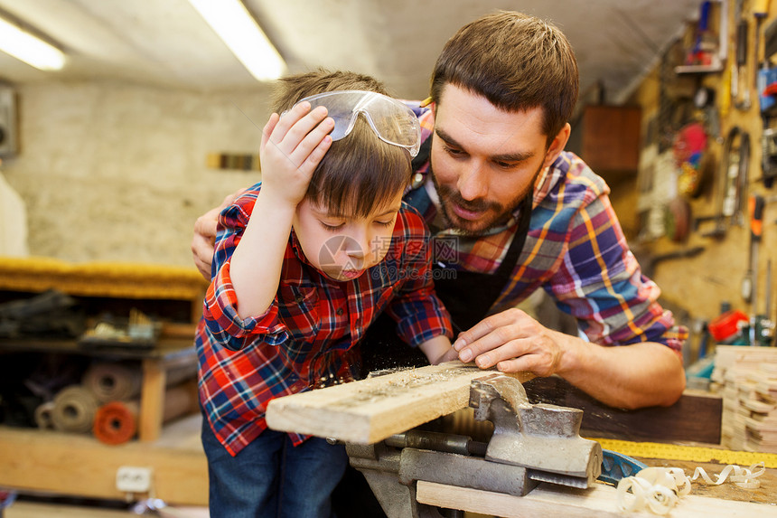 家庭,木工,木工人的父亲小儿子车间用木板工作图片