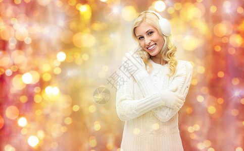 冬天,假期,诞节人们的微笑的轻女人耳罩毛衣的灯光背景图片