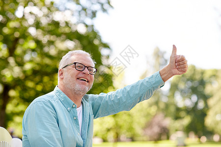 老人,手势人的快乐的老人戴着眼镜,坐夏季公园,竖大拇指图片
