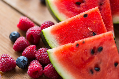 健康的饮食,食物,饮食素食的树莓,蓝莓西瓜片木桌上背景图片