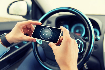 交通,商务旅行,技术人的男的手与音乐音符图标智能手机屏幕上的汽车图片