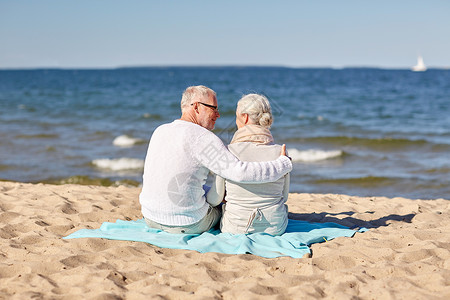家庭,龄,旅游,旅游人的快乐的老夫妇坐格子拥抱夏季海滩美丽的高清图片素材