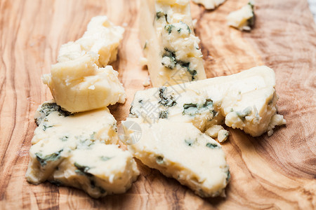 蓝色奶酪靠近橄榄木木板罗克福特核桃背景图片
