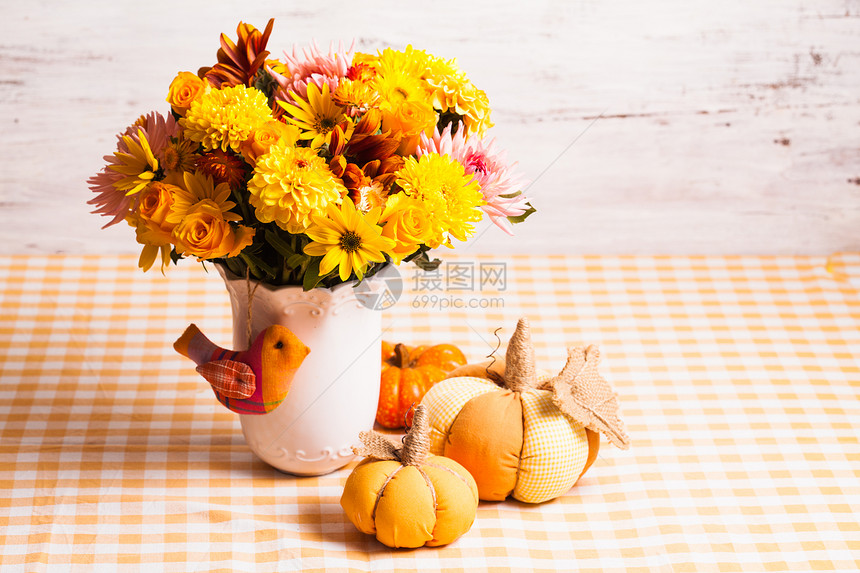 桌子上花小橙色纺南瓜的花瓶秋天的装饰图片