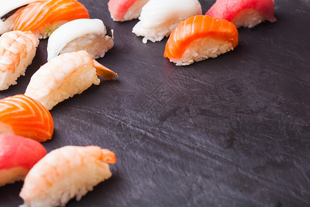 特写四套寿司与鲑鱼,金鱼,扇贝虾黑色背景与图片