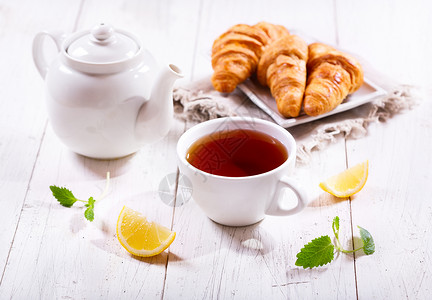 茶壶杯木制桌子上薄荷柠檬的茶图片