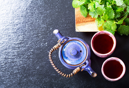 茶壶茶杯与薄荷黑暗的背景,顶部的图片