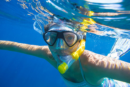 轻的女人热带水中浮潜背景图片