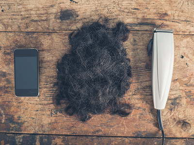 部智能手机,堆头发些剪头发的木桌上图片