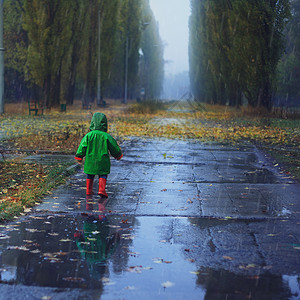 小孩靴子蹒跚学步的孩子秋雨公园跑步背景