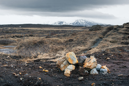 多云的天气里,冰岛的景观田野上岩石高清图片