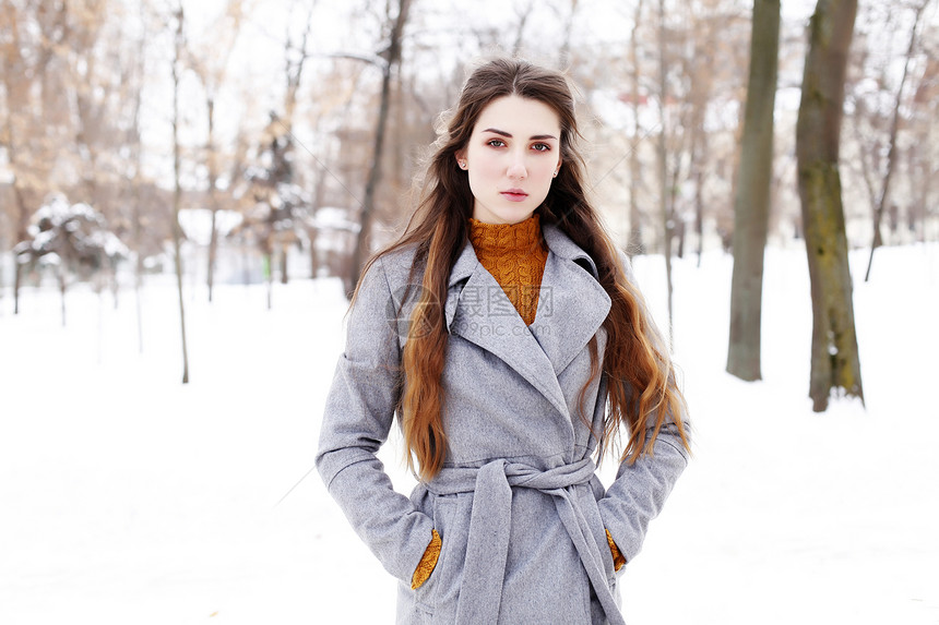 户外冬季肖像轻迷人的女人穿着灰色长外套摆姿势城市,街头时尚冬天街上的漂亮感女孩图片