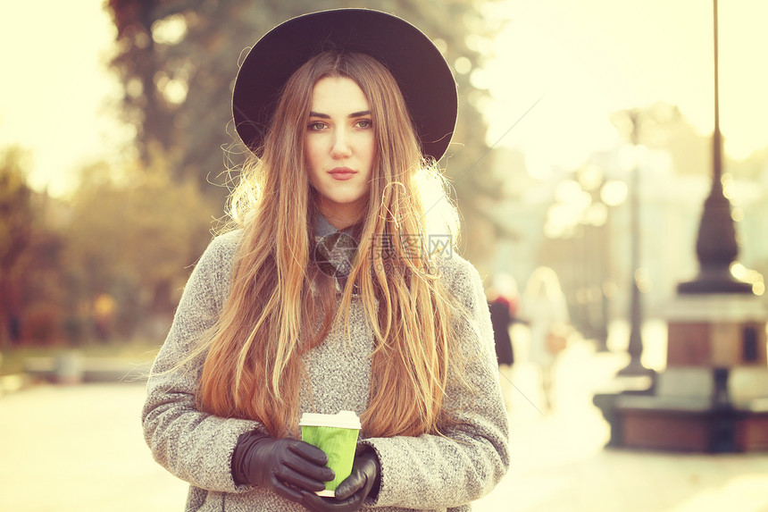 阳光生活方式的照片,轻时尚的时髦女人走街上,戴着可爱的时髦帽子,户外喝热铁咖啡时尚博主服装照片色调风格Insta图片