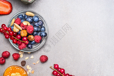 新鲜的夏季浆果坚果灰色的石头背景,顶部视图健康食品清洁饮食理念图片