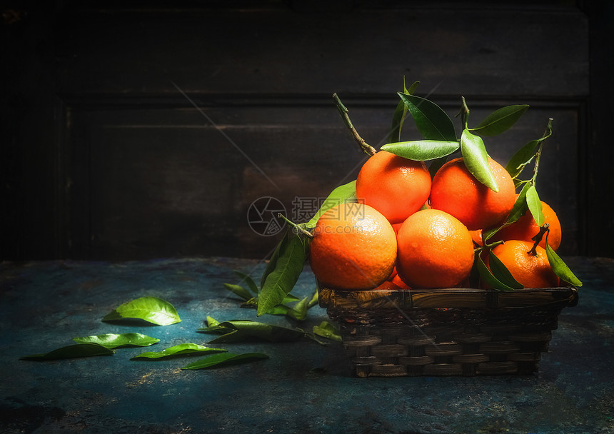 篮子与新鲜橘子与绿叶图片