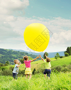 欢快的孩子们新鲜的草地上玩气球图片