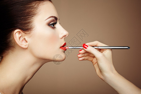 粘滞剂化妆师涂口红漂亮的女人脸完美的妆容背景