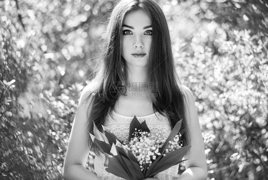 美丽的轻女子与百合花的山谷肖像关于自然的女孩春天的花朵时尚美黑白相间图片
