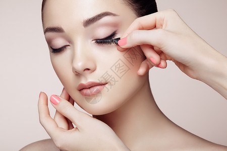 化妆师粘睫毛漂亮的女人脸完美的妆容美容时尚睫毛化妆品眼影图片