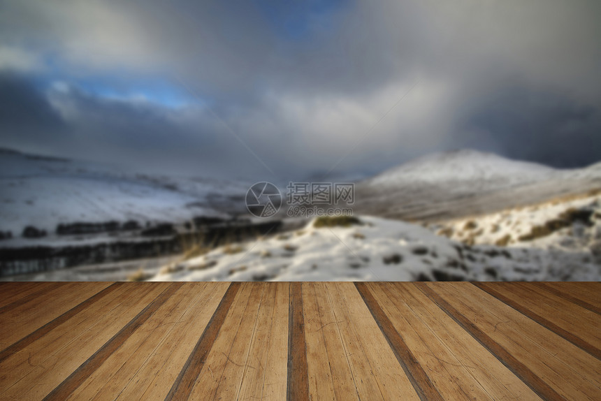 美丽的雪景覆盖了山脉冬季下午晚些时候与木制木板地板图片