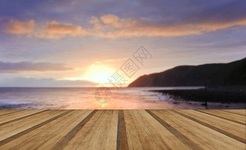 日出的潮水与岩石前景悬崖与木制木板地板背景图片