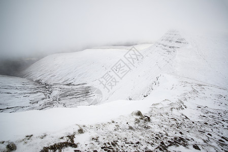喜怒无常的低云冬季景观山上与地雪高清图片