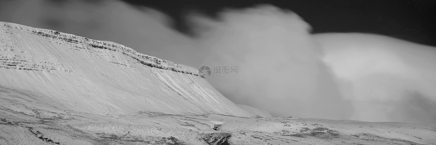 令人惊叹的冬季全景景观,雪覆盖着黑白相间的山脉图片