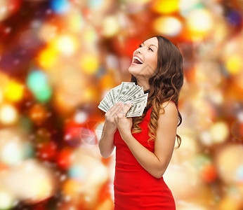 连衣裙女人诞节,假日,销售,银行人的微笑的女人穿着红色的衣服,红灯的背景下美元的钱设计图片
