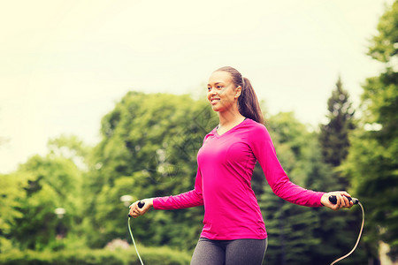 健身,运动,训练,公园生活方式的微笑的非裔美国妇女锻炼与跳绳户外图片