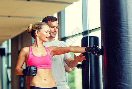 运动,健身,生活方式人的微笑的女人与私人教练拳击健身房图片