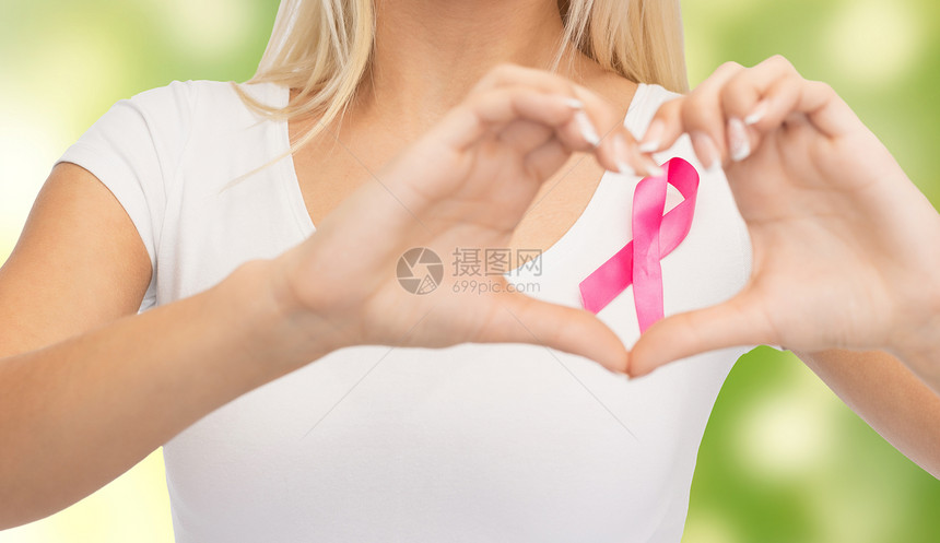 医疗保健,人,慈善医学特写轻妇女的空白白色t恤与粉红色乳腺癌意识丝带心形绿色背景图片