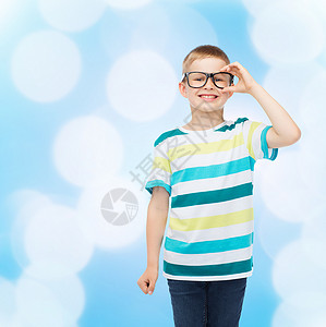 视觉,教育学校微笑的小男孩戴着蓝色背景的眼镜图片