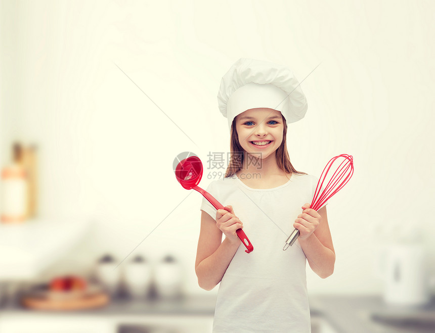 烹饪人们的微笑的小女孩烹饪帽子与瓢搅拌图片