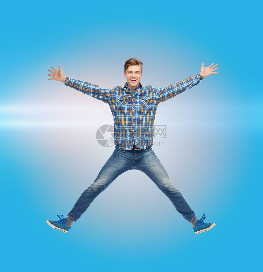 幸福自由运动人的微笑的轻人蓝色激光背景下空中跳跃图片