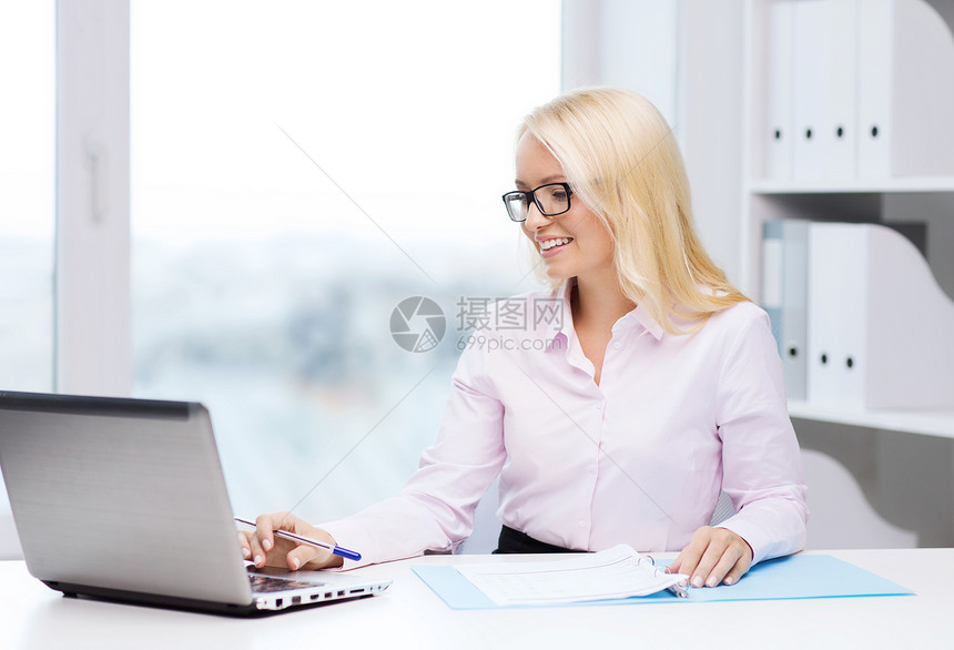 教育商业技术微笑的女商人戴眼镜的学生,办公室里笔记本电脑文件图片