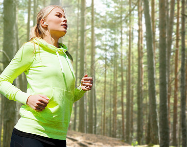 人,运动,健身减肥的快乐的女人跑步慢跑树林背景图片