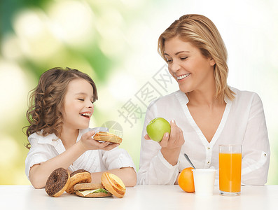 人们,健康的生活方式,家庭食物的快乐的母亲女儿绿色背景下吃健康的早餐图片
