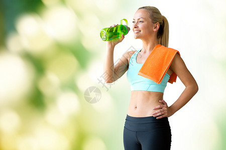 健身,运动,训练,饮料生活方式的妇女与瓶水毛巾绿色的自然背景图片