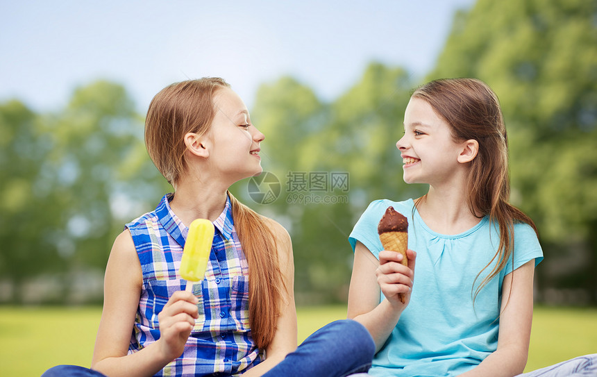 人孩子朋友友谊的快乐的小女孩夏天的公园背景下吃冰淇淋图片