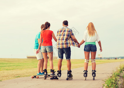 假期,爱友谊的群青少带着溜冰鞋滑板后骑户外背景图片