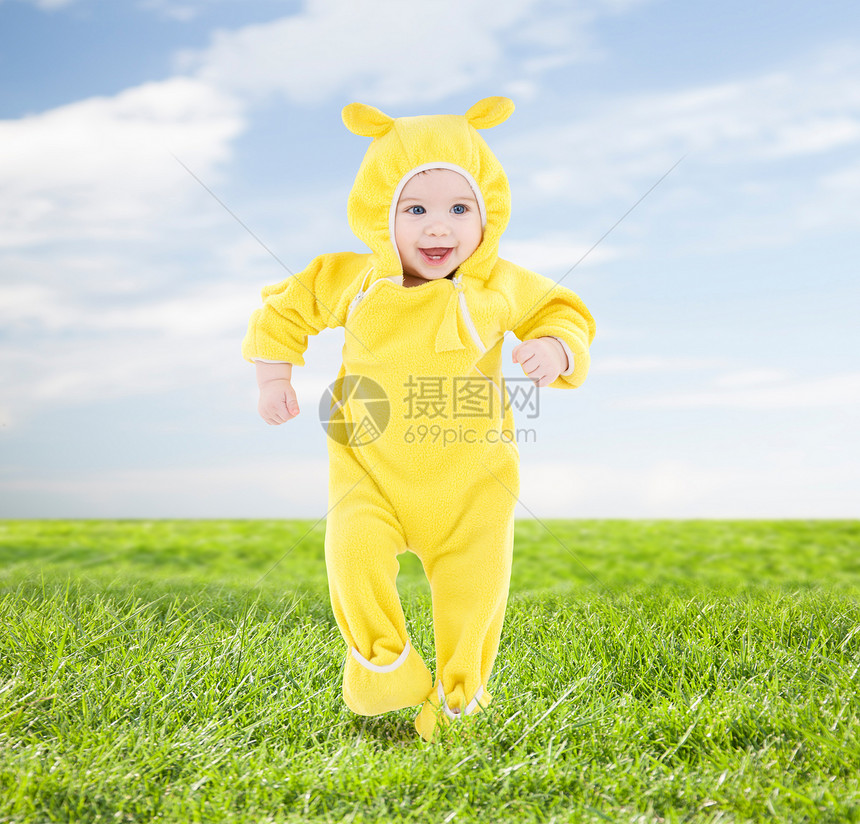 人,孩子,成就幸福的穿着黄色西装的快乐宝宝蓝天草地背景上迈出了步图片