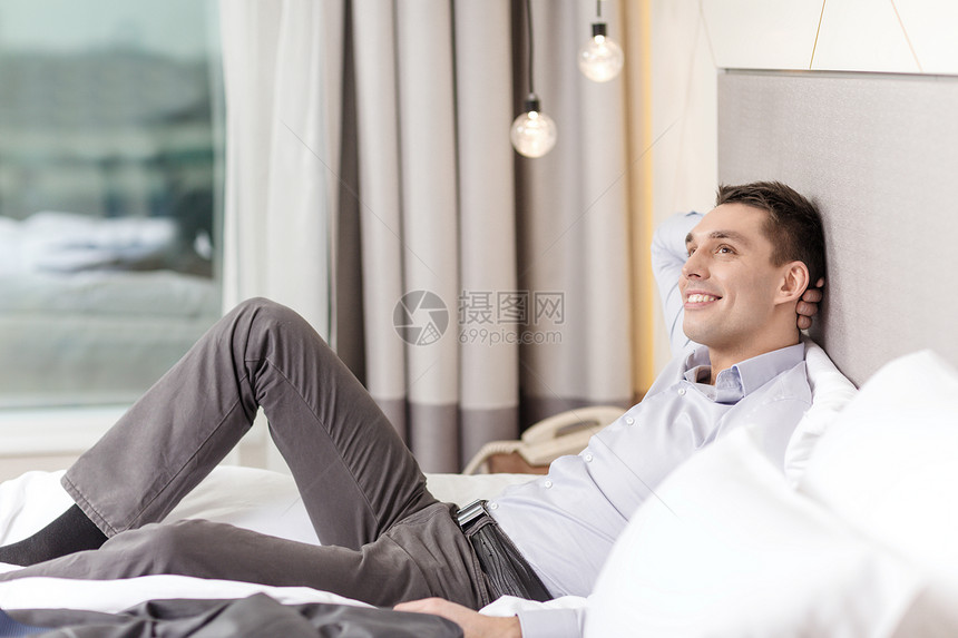 商业技术互联网酒店理念快乐的女商人躺酒店房间的床上图片